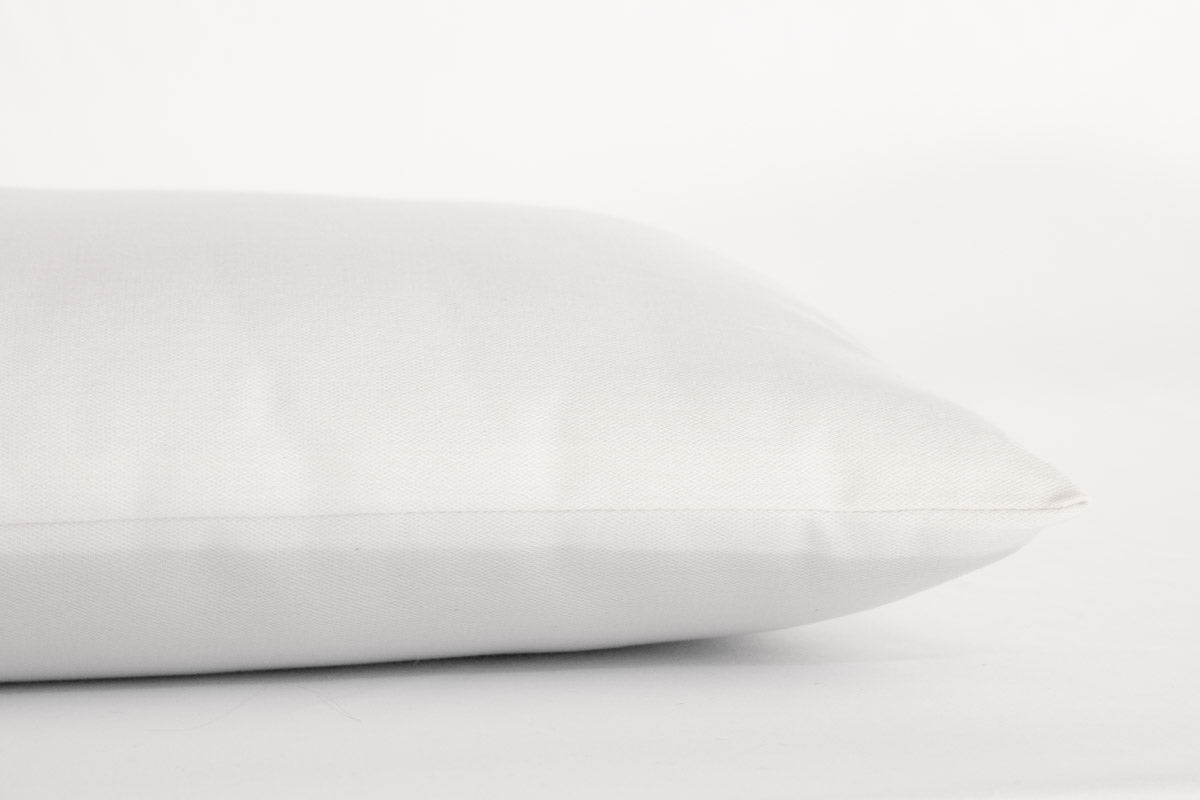 A close-up of a Shepherd's Dream Child's Sleep Pillow on a plain white background, featuring one corner and part of the side. The fabric appears smooth and slightly textured, emphasizing its natural bedding appeal made from toxic-free materials.