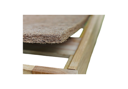 Close-up of a wooden frame with the CocoCoir Comfort Pad by Shepherd's Dream resting on top, showcasing its textured, woven coconut coir design. The focus is on the corner of the frame and the edge of the pad, emphasizing the contrast between the smooth wood and its rough texture.