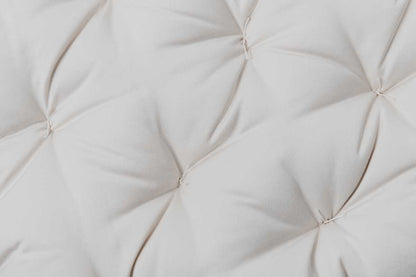 Close-up of a tufted Snuggle Mate Wool Topper by Shepherd's Dream, featuring EcoWool® fabric with soft folds in a light hue, creating a textured and detailed surface.