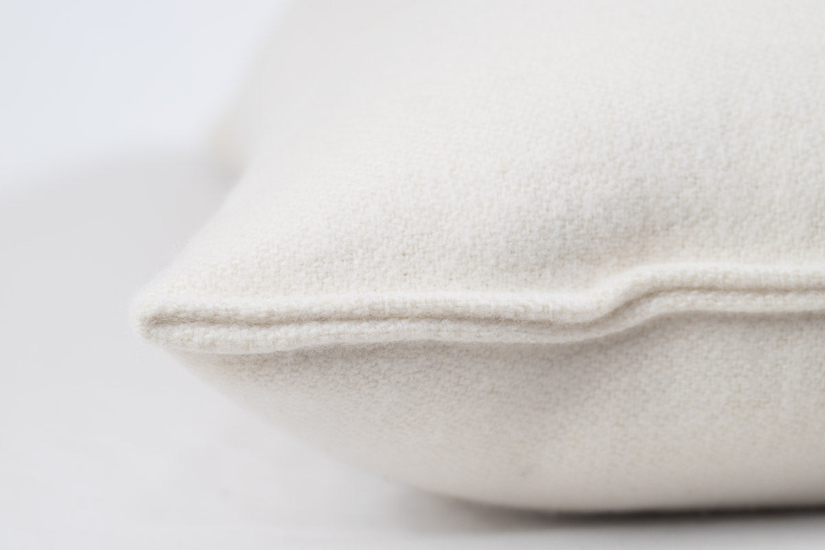 Close-up of the All Wool Dream Pillow by Shepherd's Dream in beige, crafted from Merino wool. The image focuses on the corner, showcasing the EcoWool® batting and detailed stitching. The pillow's soft texture and allergen-reducing surface are emphasized against a blurred background.