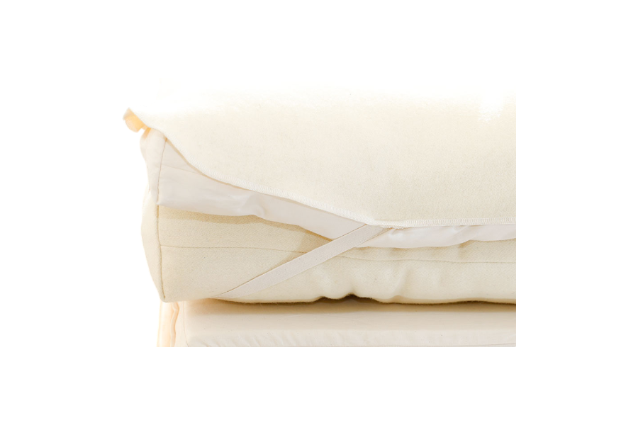 Folded Wool Mattress Protector from Shepherd's Dream, featuring attached elastic straps and dust mite-resistant, breathable wool, displayed against a plain background.